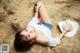 A woman laying on a pile of hay wearing a cowboy hat.