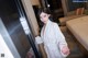 A woman in a white robe standing in a hotel room.