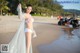 A woman in a white bikini standing on a beach.