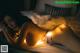 A woman laying on a bed with a string of lights around her body.