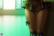 A woman in a green skirt and stockings standing in front of a window.