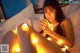 A woman laying on a bed holding a string of lights.