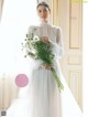 A woman in a wedding dress holding a bouquet of flowers.